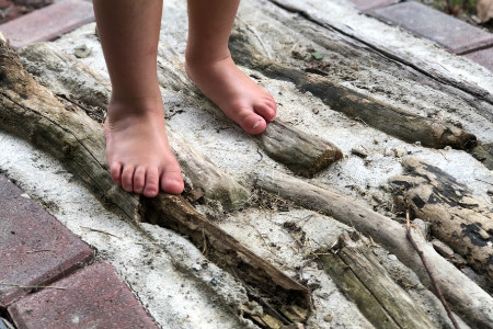 feet on a portion of a path made from branches