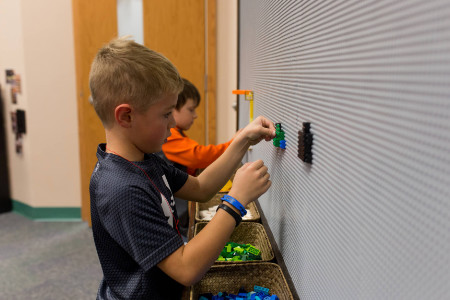 two boys building on the Lego wall