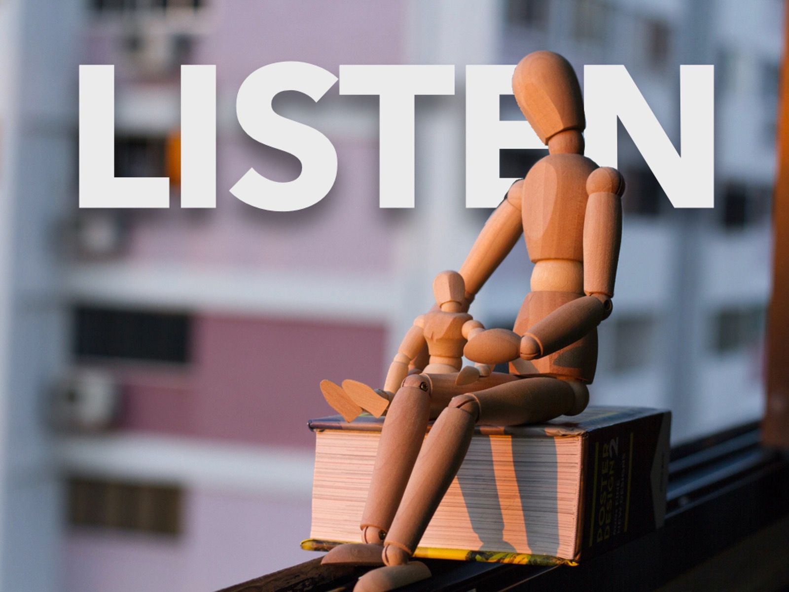 wooden dolls sitting in front of the word listen